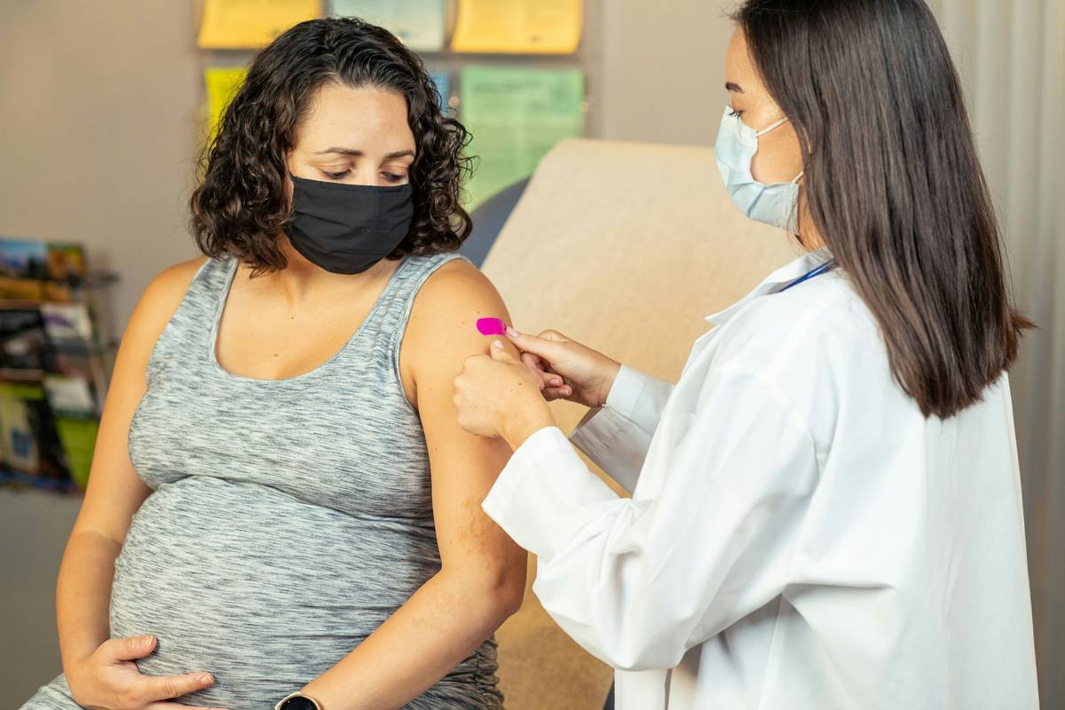 Doctor holding bottle of prenatal vitamins recommended by obgyn during consultation